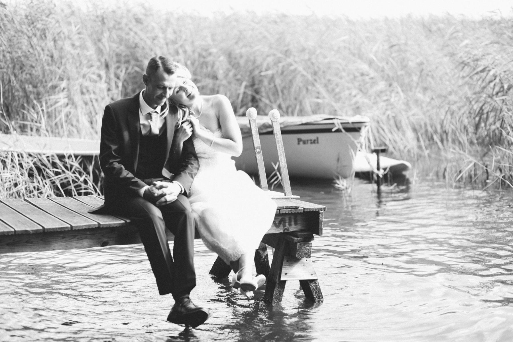 Brautpaar sitzt auf Bootssteg am Wandlitzsee
